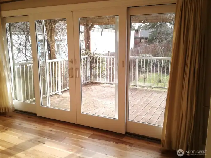 Bedroom #1 - primary shows the full length of light filled windows and sliders before sellers moved in