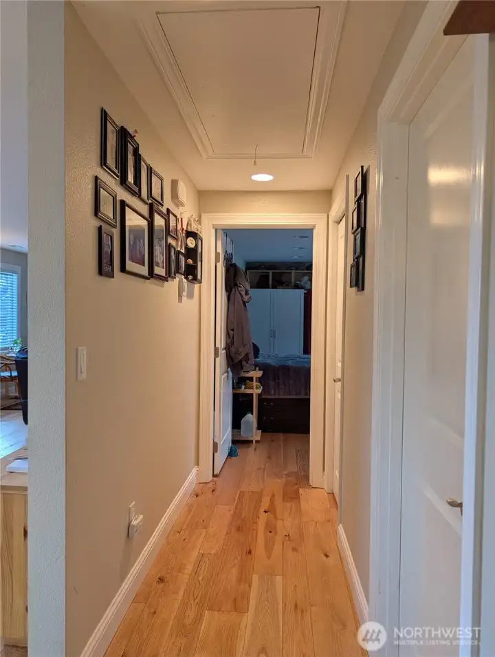 Hallway - notice the beautiful hardwood floors which go throughout the home.  Also notice there is a pull-down stairway to the attic. New furnace is in attic. there is some flooring up there too.