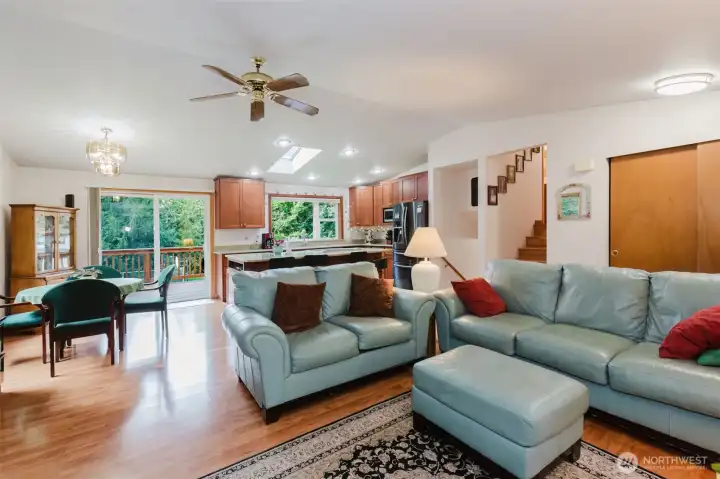 Inside, a skylight, expansive windows, and a patio door bathe the space in natural light, creating an inviting, sun-washed ambiance throughout.