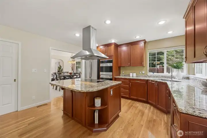 The heart of the home features a gourmet kitchen adorned with granite countertops and warm wood cabinetry.