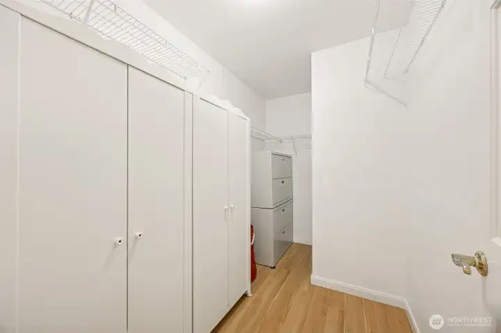 Generous walk-in closet offers tasteful built-in armoires to hold all your personal storage needs.