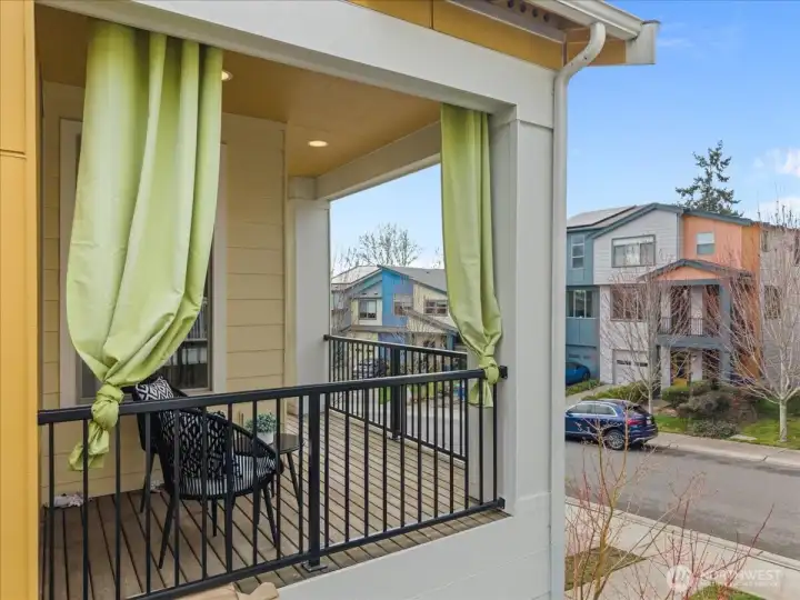 Balcony adjacent to the living room with a railing and covered structure, offering an outdoor seating area.
