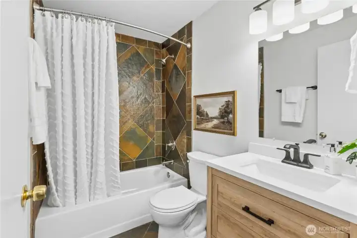 Main floor shared FULL bath with new vanity, lighting, toilet, paint, and mirror!