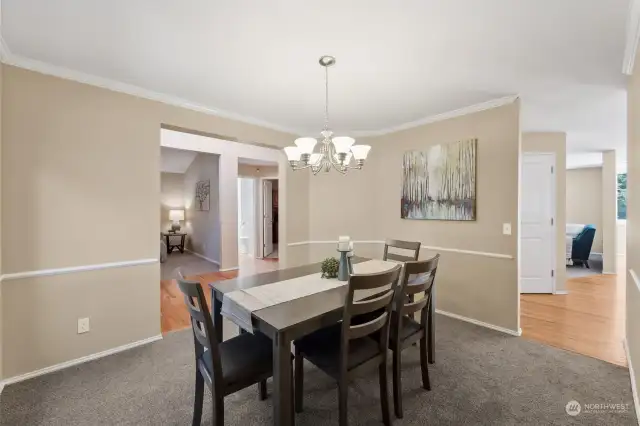 Spacious dining room with chair rail & crown molding.