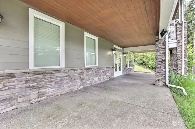 View of the covered patio and entrance to the lower level. I love all the stone and wood, definitely a classic Pacific NW feel.