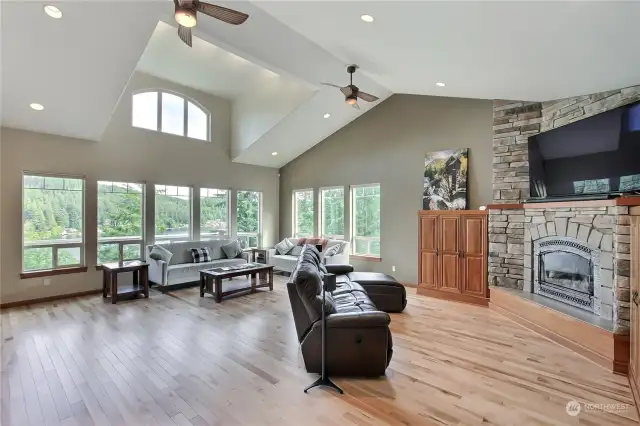 So much to love about this great room, the new hardwood floors, expansive windows leading out to your deck, built-ins around the propane fireplace, cathedral ceilings!