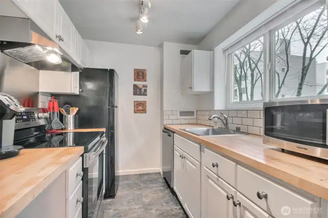 Light & bright kitchen. Updated kitchen features butcher block counters, subway tile backsplash, and stainless steel appliances.
