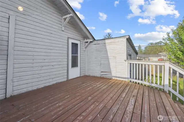 Back deck and man door leading into one car garage