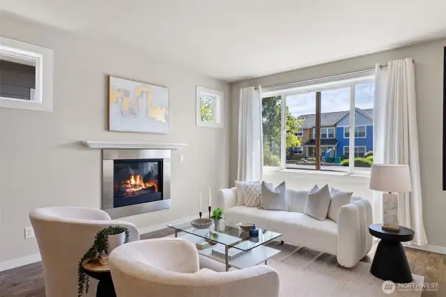 Enjoy the bright and living room featuring a cozy gas fireplace and a large picture window.
