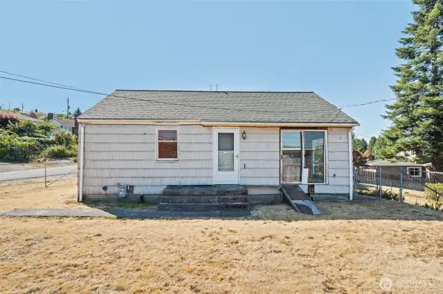 The rear entry offers convenient access to the spacious lot, making it easy to enjoy and utilize the outdoor space.