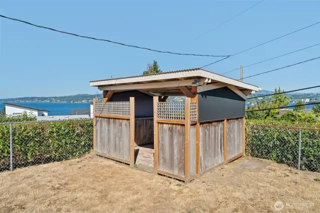 A charming covered gazebo sits in the yard, perfectly placed while offering shade, privacy, and extra storage space.
