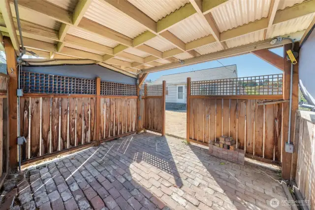Inside the covered gazebo, a brick floor and open design create a versatile area.