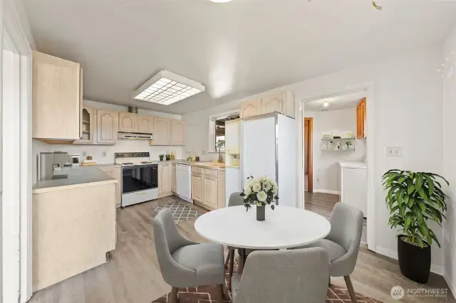 This inviting kitchen flows seamlessly into the dining space, offering plenty of room for meals and gatherings, all within steps of the laundry room for added convenience. (Virtually Staged)