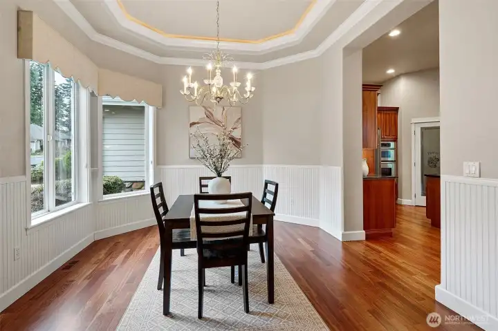 The formal dining room is just inside the front entrance and is open to the kitchen. It offers a welcoming space for elegant meals and casual gatherings, seamlessly connecting the dining experience with the heart of the home.