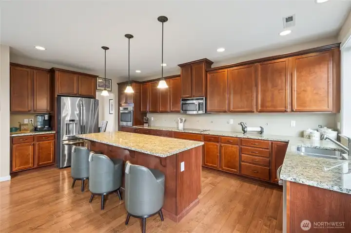 Granite countertops and a full tile backsplash add elegance and durability to the kitchen. These high-end finishes elevate the overall design.