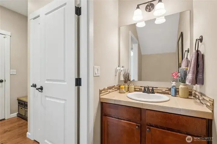 The spacious main-floor half bath is thoughtfully tucked away from the main living areas, offering privacy and convenience for guests. Its location keeps entertaining spaces uninterrupted while still being easily accessible. A well-designed feature that adds both comfort and functionality to the home.