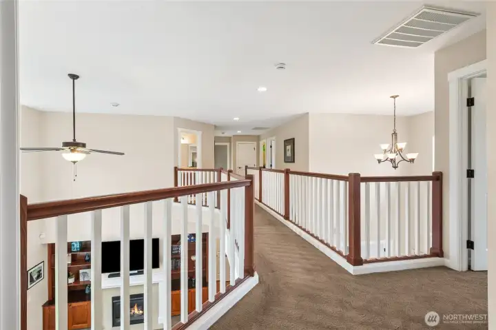 The open second-story walkway creates a dramatic architectural feature while thoughtfully separating the primary suite from the upstairs bonus room. Its open design enhances the home’s sense of space and light, while still providing privacy and functionality.