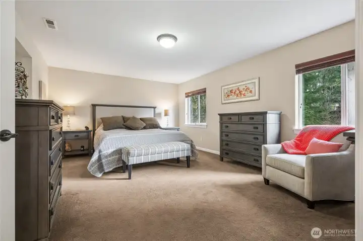 The spacious primary suite offers a true retreat, with room for a sitting area or reading nook. A calming space to unwind at the end of the day.