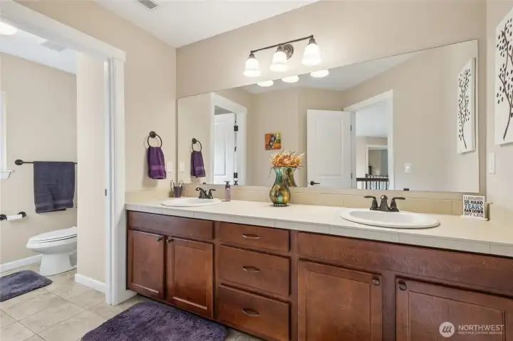 The large upstairs guest bath is designed with comfort and convenience in mind, featuring dual sinks and generous counter space. A separate water closet adds privacy and functionality, making it ideal for busy mornings or hosting guests. The spacious layout ensures plenty of room for everyone to get ready with ease.