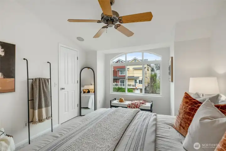 Bedroom 1 with big picture window and ceiling fan and vaulted ceilings.