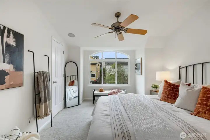 Bedroom 1 with walk in closet, big picture window and ceiling fan and vaulted ceilings.