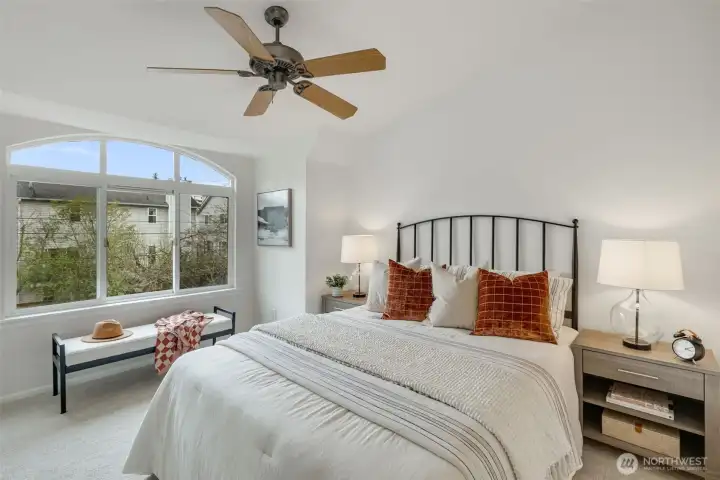 Bedroom 1 with big picture window and ceiling fan and vaulted ceilings.