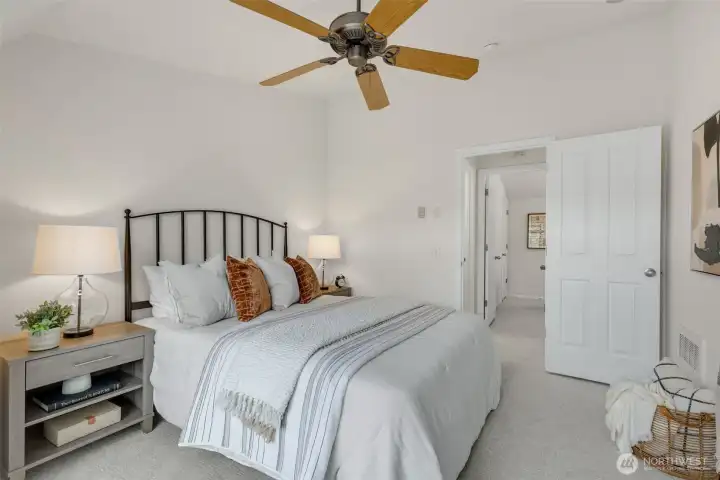 Bedroom 1 with big picture window and ceiling fan and vaulted ceilings.