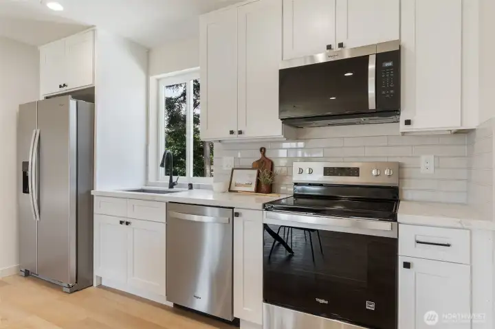 Kitchen has stainless appliances including the fridge.