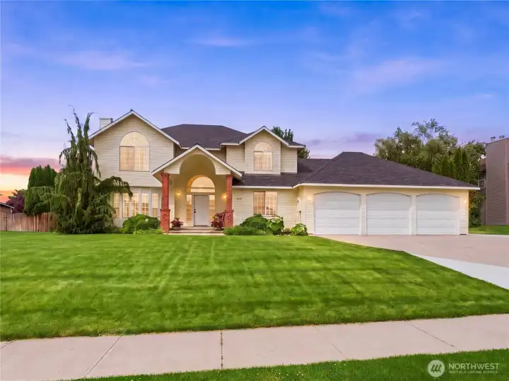 Beautiful curb appeal with mature landscaping and spacious driveway leading to oversized heated 3-car garage.