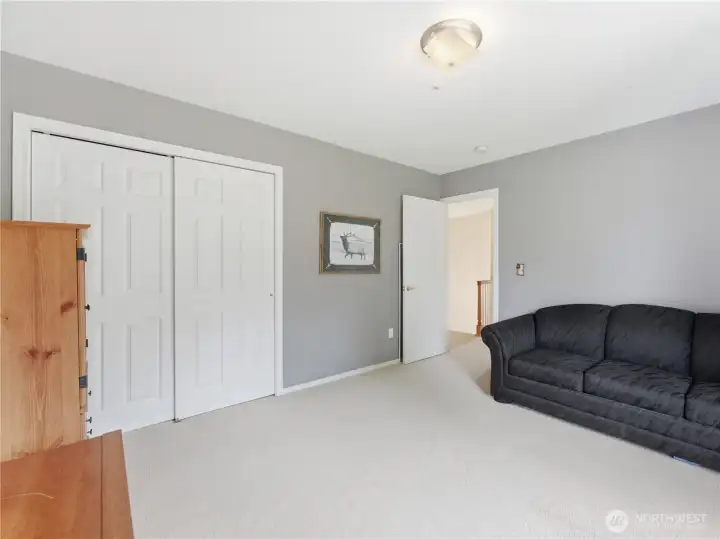 Bright guest bedroom with generous square footage and abundant natural light.