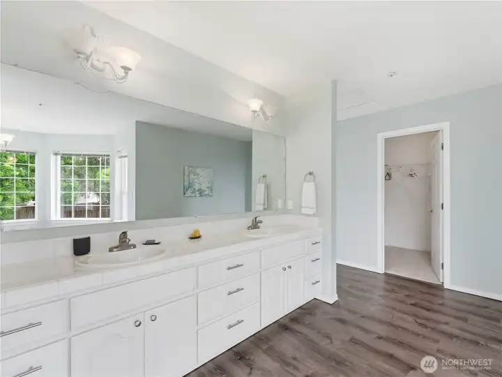 Upgraded primary bathroom featuring stylish LVP flooring and modern finishes.
