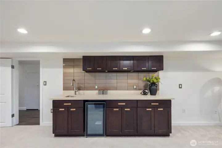 Expansive lower level offers the perfect setting for a media room, play space, or recreation area, complete with a convenient wine fridge.