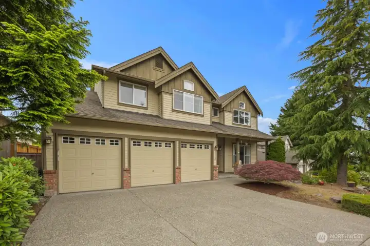 A wide driveway, mature trees, and a three-car garage create a welcoming first impression. A wide driveway, mature trees, and a three-car garage create a welcoming first impression.