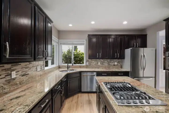 Designed for both function and storage, the kitchen includes generous counter space, stainless steel appliances, and an island work area. Designed for both function and storage, the kitchen includes generous counter space, stainless steel appliances, and an island work area.