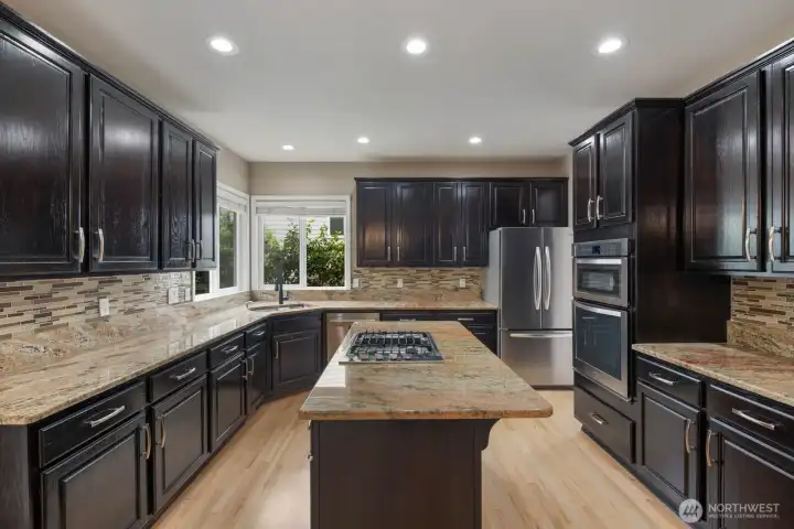 Multiple work zones, extensive cabinetry, and a gas cooktop provide flexibility for cooking and entertaining. Multiple work zones, extensive cabinetry, and a gas cooktop provide flexibility for cooking and entertaining.