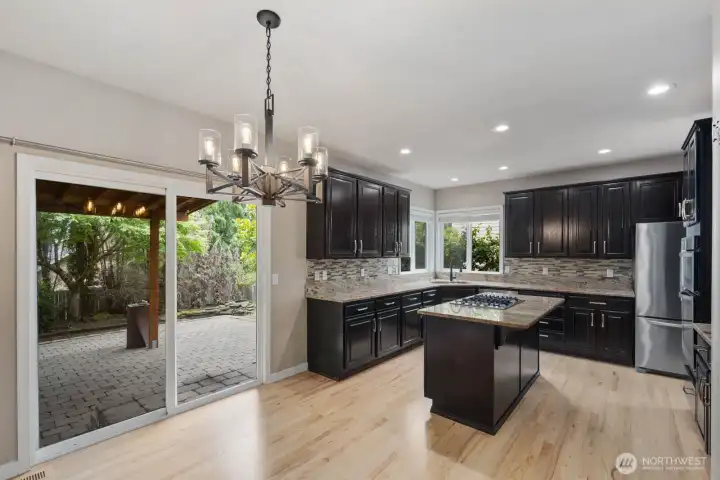 Spacious main-level room with a gas fireplace, recessed lighting, and large windows overlooking the backyard. Spacious main-level room with a gas fireplace, recessed lighting, and large windows overlooking the backyard.