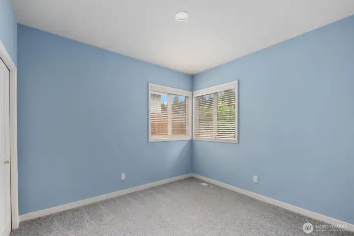 Spacious bedroom with corner windows, abundant natural light, and views of the surrounding landscape. Spacious bedroom with corner windows, abundant natural light, and views of the surrounding landscape.