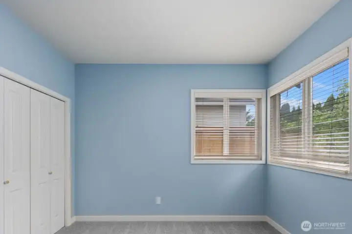 Large bedroom featuring multiple windows, a neutral color palette, and plenty of space for a variety of furniture layouts. Large bedroom featuring multiple windows, a neutral color palette, and plenty of space for a variety of furniture layouts.