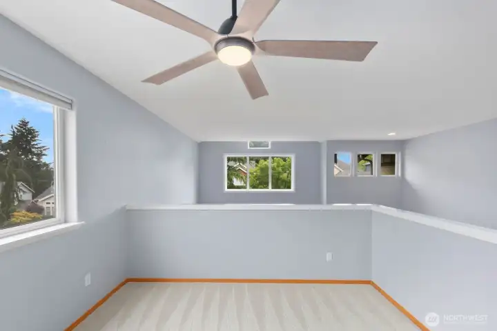 Another view of the upper-level bonus area showcasing the open design, ceiling fan, and multiple windows that bring in natural light throughout the day. Another view of the upper-level bonus area showcasing the open design, ceiling fan, and multiple windows that bring in natural light throughout the day.