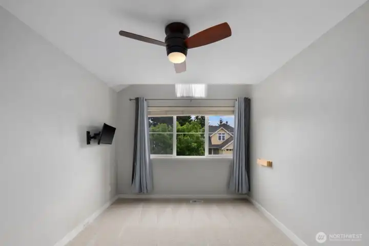 Additional view of the bedroom highlighting the vaulted ceiling, ceiling fan, and generous window that fills the space with natural light. Additional view of the bedroom highlighting the vaulted ceiling, ceiling fan, and generous window that fills the space with natural light.