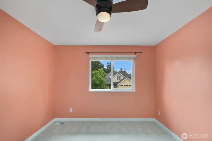 Another view of the bedroom showcasing the window placement, ceiling fan, and versatile layout that can accommodate a variety of needs. Another view of the bedroom showcasing the window placement, ceiling fan, and versatile layout that can accommodate a variety of needs.