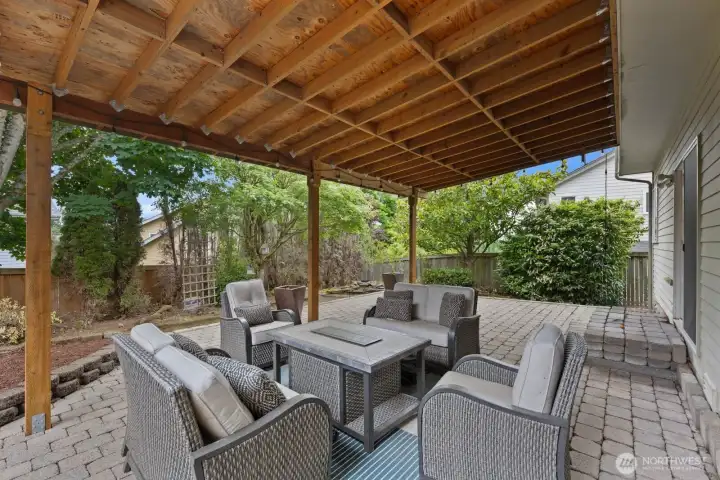 Covered outdoor living area with paver patio and space for seating, dining, or entertaining. A comfortable extension of the home surrounded by mature landscaping. Covered outdoor living area with paver patio and space for seating, dining, or entertaining. A comfortable extension of the home surrounded by mature landscaping.