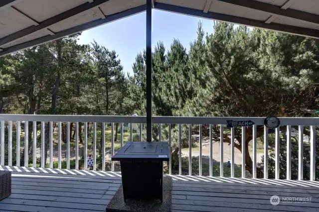 The main floor covered wrap around deck with barbeque and propane firepit.