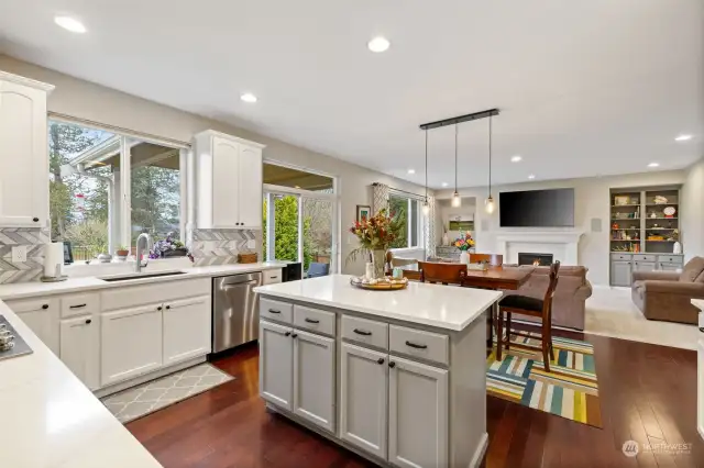 Kitchen with updated counters, backsplash, lighting and paint. Looking toward informal eating space and family room.  Sliding doors provide access to patios and back yard.