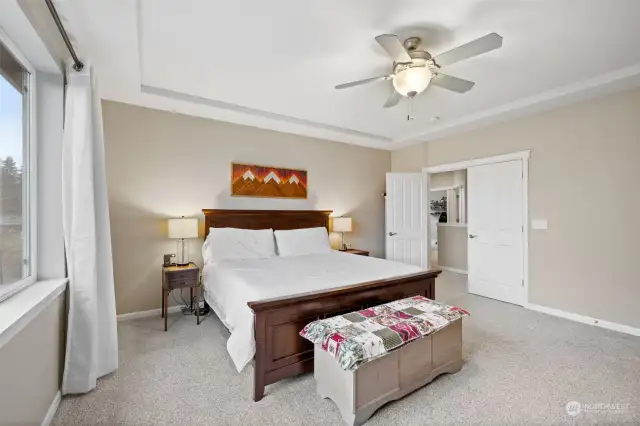 Second view of primary bedroom, showing double doors and view toward hallway/landing.