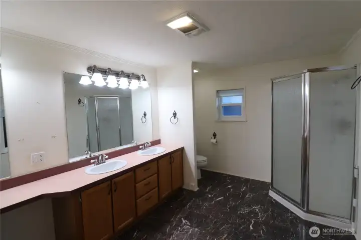 Double sink vanities and a make up area with storage and spacious area.