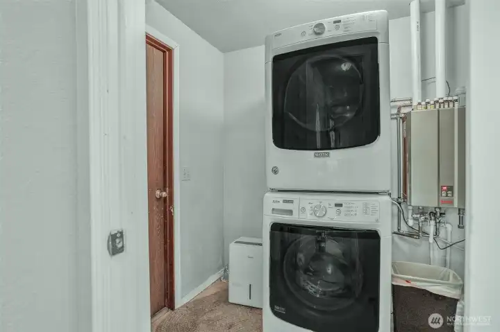 Laundry room off of garage with tankless hot water tank. Washer & dryer included.