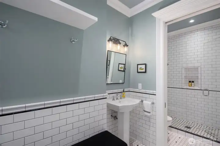 The lower level bathroom offers entry from both inside and out making this the perfect changing room with bench and storage for pool days.