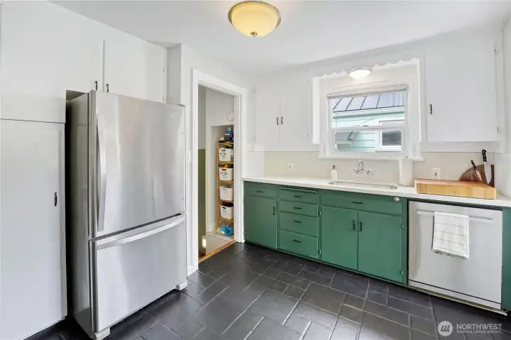 A modern kitchen with stainless steel appliances, an eating nook, and quartz