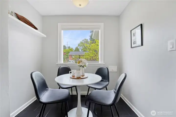 A modern kitchen with stainless steel appliances, an eating nook, and quartz